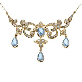 An aquamarine and split pearl necklace. The oval-shape aquamarine and split pearl scrolling panel, s