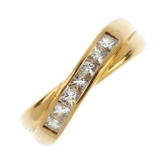 An 18ct gold diamond crossover ring. The square-shape diamond diagonal line, to the grooved sides an