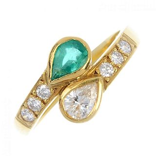 An 18ct gold diamond and emerald crossover ring. The pear-shape emerald and diamond asymmetric termi