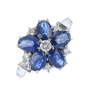 An 18ct gold sapphire and diamond cluster ring. The brilliant-cut diamond, within an oval-shape sapp