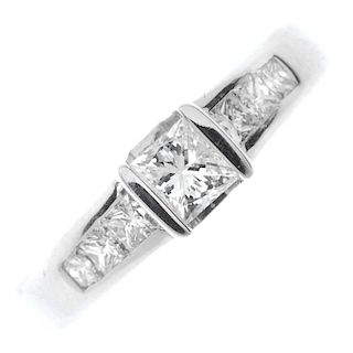 An 18ct gold diamond single-stone ring. The square-shape diamond, with similarly-cut diamond line sh