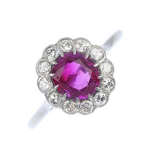 An early 20th century platinum Burmese ruby and diamond cluster ring. The oval-shape ruby, measuring