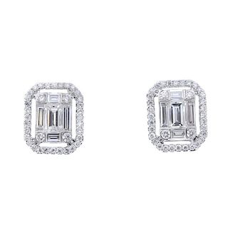 A pair of diamond ear studs. Each designed as a baguette-cut diamond, within a baguette and brillian