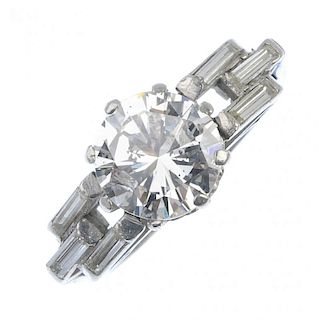 A diamond single-stone ring. The brilliant-cut diamond, with baguette-cut diamond geometric sides, t