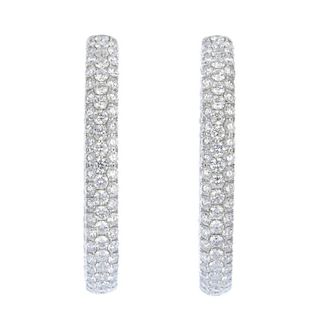 A pair of 18ct gold diamond ear hoops. Each designed as a pave-set diamond hinged hoop. Estimated to