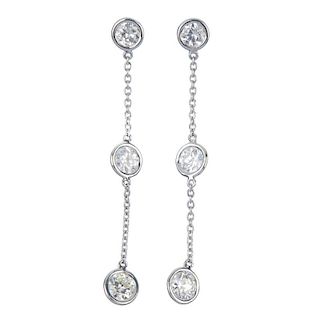 A pair of diamond ear pendants. Each designed as a two circular-cut diamond collets, spaced along a