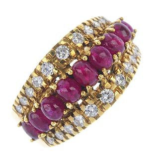An 18ct gold ruby and diamond dress ring. The graduated oval ruby cabochon line, raised to brilliant