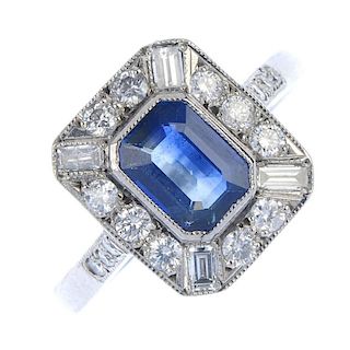 A sapphire and diamond cluster ring. The rectangular-shape sapphire, within a brilliant and baguette