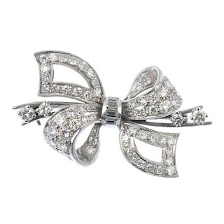 A diamond bow brooch. The pave-set single and brilliant-cut diamond loops and ribbon, gathered by a