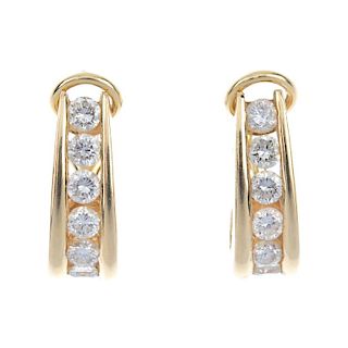 A pair of diamond ear hoops. The curved brilliant-cut diamond line, to hinged back-fitting. Estimate