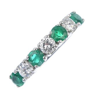 A emerald and diamond seven-stone ring. The alternating circular-shape emerald and brilliant-cut dia