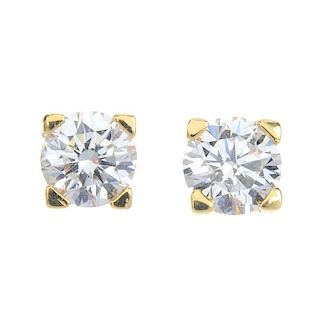 A pair of diamond single-stone ear studs. Each designed as a brilliant-cut diamond, within a corner