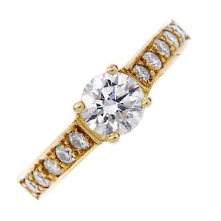 An 18ct gold diamond single-stone ring. The brilliant-cut diamond, to the pave-set diamond shoulders