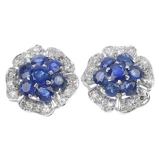 A pair of sapphire and diamond floral ear studs. Each designed as a circular-shape sapphire cluster,