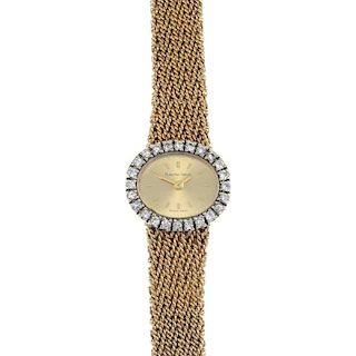A lady's 1970s 9ct gold cocktail watch. The oval dial, with baton hour markers, to the brilliant-cut