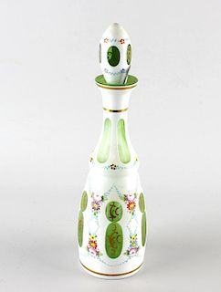 A Bohemian overlay glass bottle and stopper, of green glass having white overlay decorated with flor