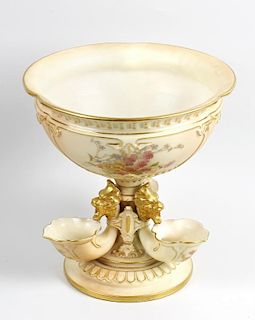 A Royal Worcester pedestal dish. The bowl decorated with floral panels raised upon three grotesque m