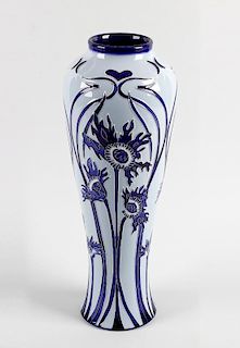 A modern Moorcroft pottery vase. Of slender baluster form decorated to the whole with Florian-style