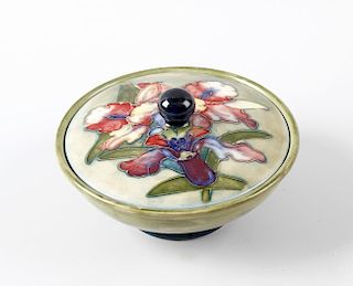A Moorcroft pottery Orchid pattern bowl and cover. Circa 1950, the hemispherical bowl having a tube-