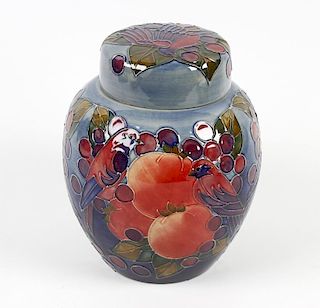 A Moorcroft pottery jar and cover, the ovoid body having blue/green glaze ground decorated with frui