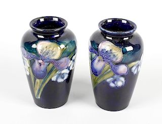 A small pair of Moorcroft orchid vases. The ovoid bodies having blue glazed ground decorated with or