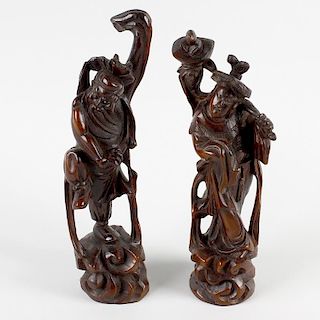 A pair of Oriental carved rootwood figures. One modelled as a muscular bearded figure with one foot