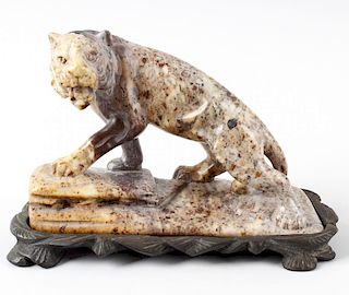 An Eastern hardstone figure of a tiger. Stood in crouched stance with open mouth upon a rocky base a