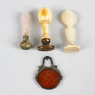 Three 19th century desk seals and a fob. Comprising a turned ivory example, the oval brass seal with