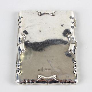 An Edwardian silver aide-memoire. Of hinged rectangular form with moulded scroll edges, enclosing vi