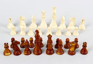 A stained ivory chess set. Comprising natural and brown stained sectional pieces, the kings of typic