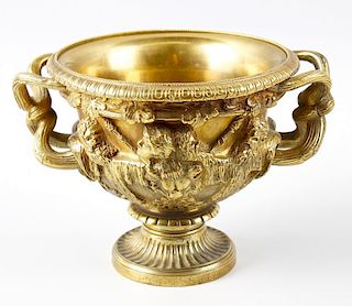 A 19th century small bronze Warwick vase. The relief cast Bacchanalian frieze above formal leaf bord