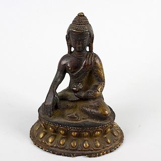 A South East Asian cast bronze figure of a Buddha. Modelled in seated Lotus position holding a vesse