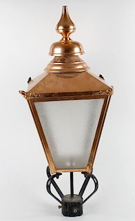 A reproduction copper lantern. The tiered spire finial over pyramidal top and tapering four sided bo