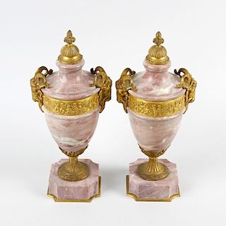 A pair of ormolu-mounted pink marble urns. Each of neoclassical form with cast domed finial over a p
