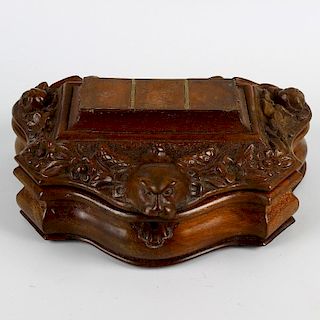 An unusual Victorian carved mahogany desk stand or writing box. Of serpentine form, the hinged cover
