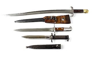 An early 20th century Swiss bayonet with wooden handle, steel scabbard and attached leather frog, a