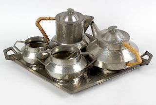 A box of assorted collectables. To include an Art Deco style hammered pewter five piece tea set, an