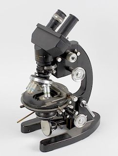 A box containing a Cooke, Troughton & Simms Ltd, black painted metal bodied microscope, with binocul