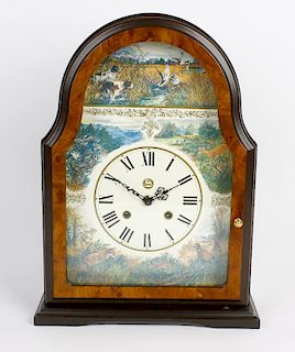 A reproduction walnut mantel clock. Decorated with various hunting scenes to the arch and spandrels,