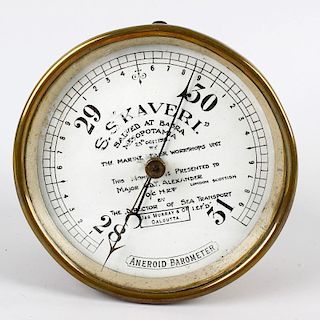 An aneroid barometer. The white-enamelled circular dial reading from 28 to 31 inches of pressure, in