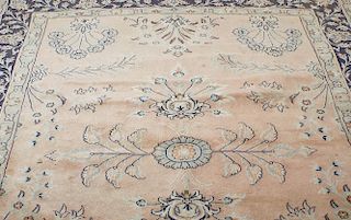 A carpet or rug. The central field sparsely decorated with floral motifs upon a pale pink ground, wi