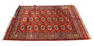 Two Eastern rugs. Comprising a Belouch/Tekke Turkoman type with three rows of eight guls on a tomato