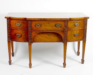 An early 19th century mahogany sideboard. Of bow-breakfront form with cockbeaded frieze drawer over