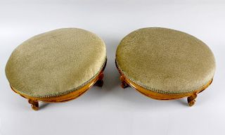 A pair of late Victorian walnut oval footstools. Each with sage green plush seat on four French cabr