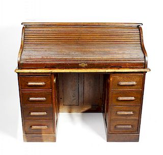 An early 20th century oak tambour pedestal desk. The S-shaped tambour enclosing drawers and pigeonho