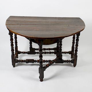 A late 17th century oak gateleg table. Having a two-plank top with oval flaps on bobbin- and ring-tu