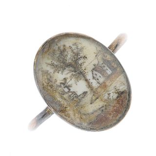 A George III ring. The oval-shape glazed picture panel depicting a scene with windmill, tree and hou