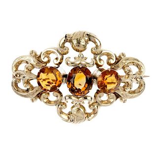 A late Victorian gold citrine brooch, circa 1880. The oval-shape citrine, with circular-shape citrin