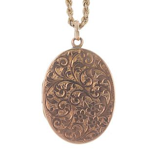 A 9ct gold locket and chain. The rope-twist chain suspending the oval-shape locket with acanthus eng