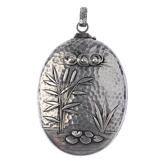 A late 19th century Aesthetic period American silver locket. Of oval outline, the hammered finish ha